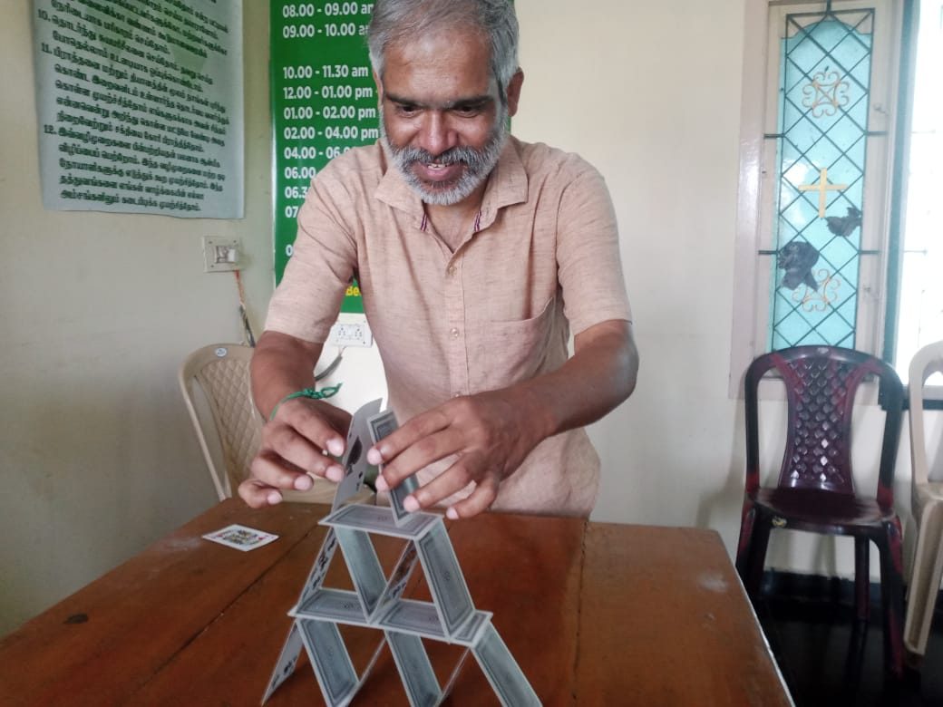 A resident building a house of cards during occupational therapy at Dunamis